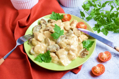 Chicken fillet with mushrooms in a frying pan in sour cream