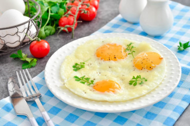 Fried eggs with cheese in a frying pan