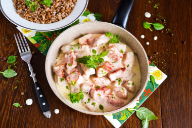 Pork in sour cream sauce in a frying pan