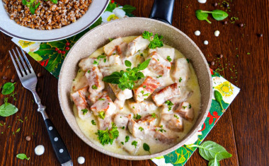 Pork in sour cream sauce in a frying pan