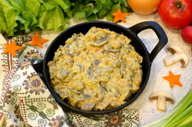 Stewed mushrooms in sour cream in a frying pan with onions