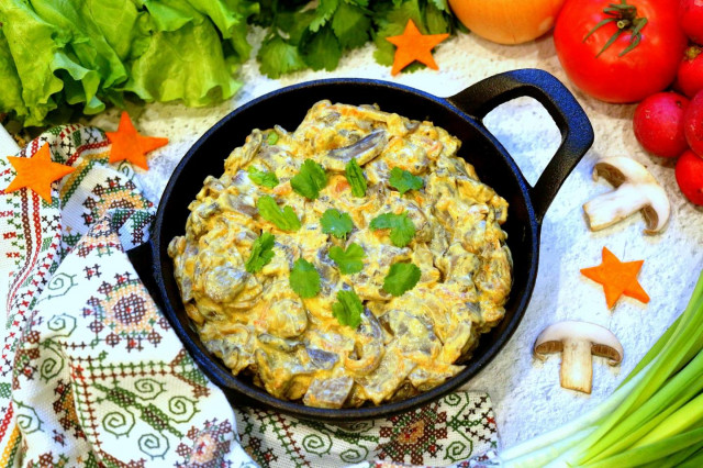 Stewed mushrooms in sour cream in a frying pan with onions