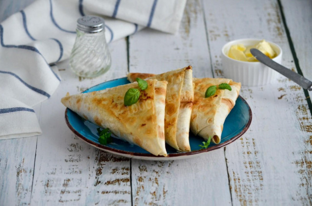 Lavash envelopes with different fillings on frying pan