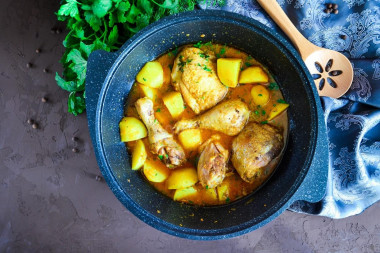 Stewed chicken with potatoes in a cauldron on the stove