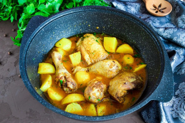 Stewed chicken with potatoes in a cauldron on the stove