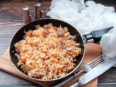 Rice with stewed meat in a frying pan