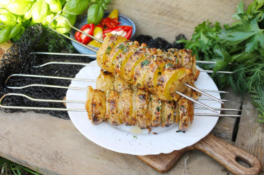 Potatoes with bacon on skewers on the grill