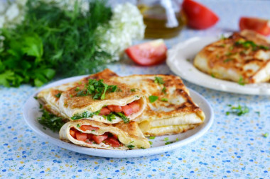 Pita bread with cheese and tomatoes in a frying pan