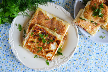 Pita bread with cheese and tomatoes in a frying pan