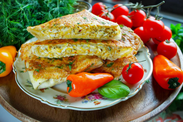 Lavash with egg and cheese in a frying pan