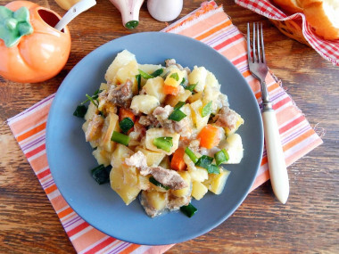 Meat and potatoes on a baking sheet in the oven