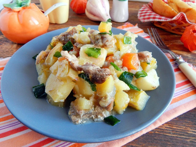 Meat and potatoes on a baking sheet in the oven