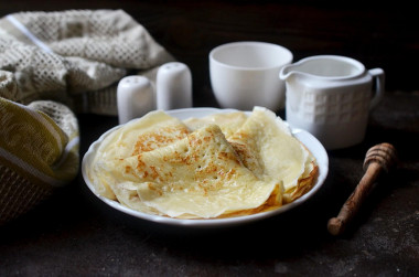 Custard pancakes with holes in boiling water and milk