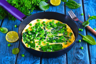 Omelet with spinach in a frying pan