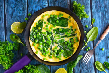 Omelet with spinach in a frying pan