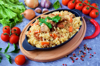 Crumbly pilaf with pork in a frying pan