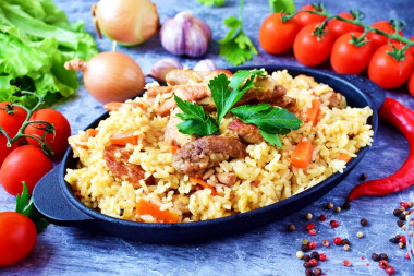 Crumbly pilaf with pork in a frying pan