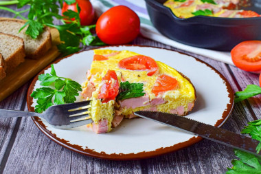 Omelet in a frying pan with sausage and cheese