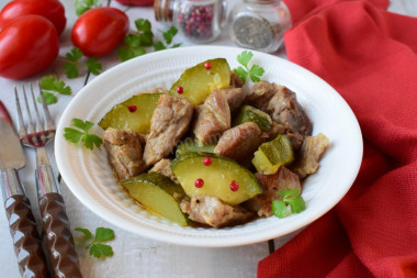 Pork with zucchini stewed in a frying pan