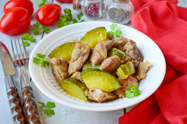 Pork with zucchini stewed in a frying pan