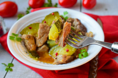 Pork with zucchini stewed in a frying pan