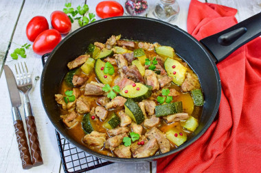 Pork with zucchini stewed in a frying pan