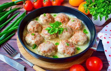 Meatballs in sour cream sauce in a frying pan