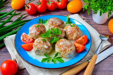 Meatballs in sour cream sauce in a frying pan