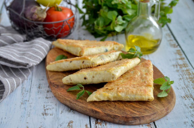 Pita bread pies with cheese in a frying pan