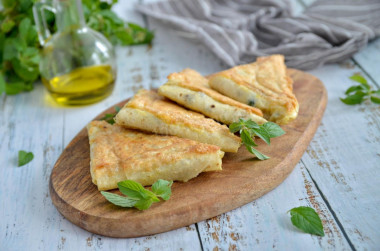 Pita bread pies with cheese in a frying pan