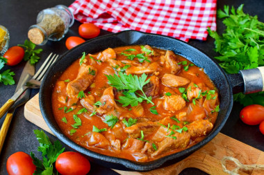 Pork meat in tomato sauce in a frying pan stewed