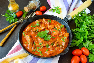 Pork meat in tomato sauce in a frying pan stewed