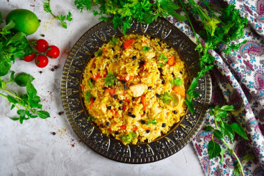 Pilaf on the stove in a cauldron of chicken