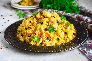 Pilaf on the stove in a cauldron of chicken