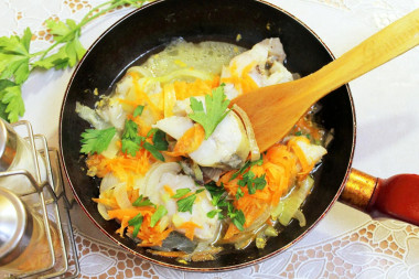 Stewed pollock with carrots and onions in a frying pan