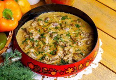 Chicken hearts and liver in sour cream in a frying pan