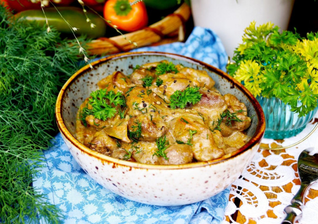 Chicken hearts and liver in sour cream in a frying pan