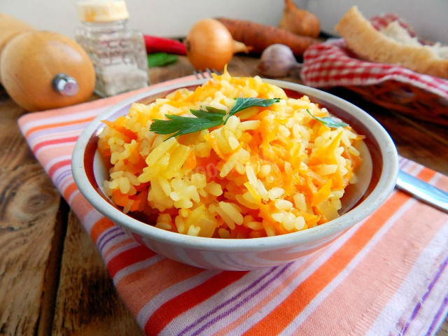 Rice in a frying pan with onions and carrots