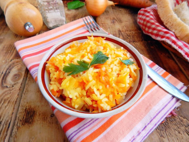 Rice in a frying pan with onions and carrots