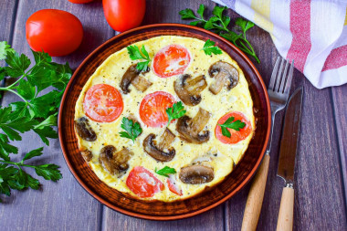 Omelet with mushrooms and cheese in a frying pan for breakfast