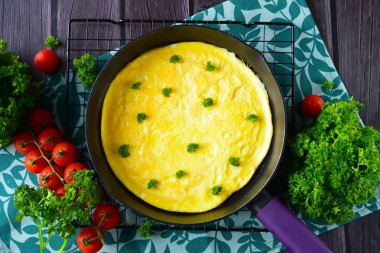 Classic omelet with milk in a frying pan