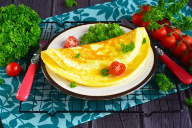 Classic omelet with milk in a frying pan