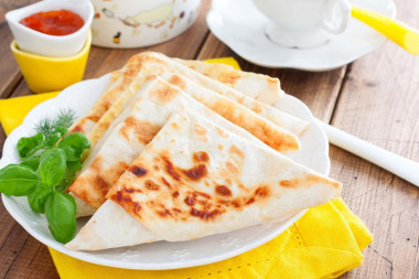 Pita bread sandwiches with cheese in a frying pan