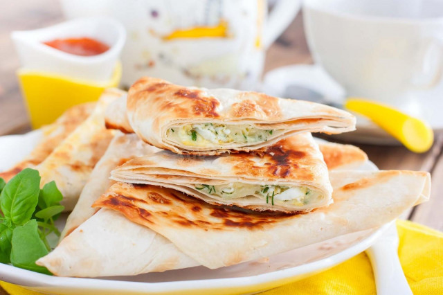 Pita bread sandwiches with cheese in a frying pan