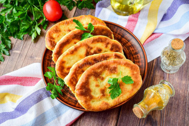 Thin pies with potatoes in a frying pan