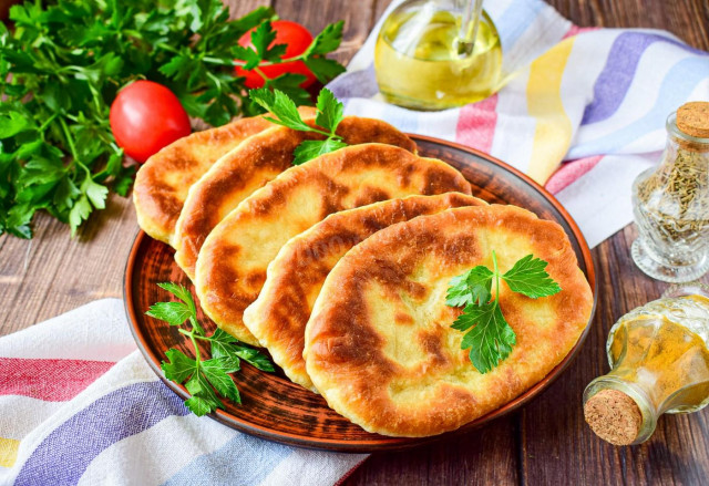 Thin pies with potatoes in a frying pan