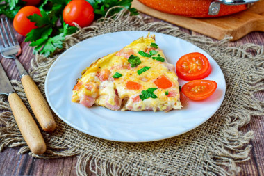 Omelet with ham and cheese in a frying pan