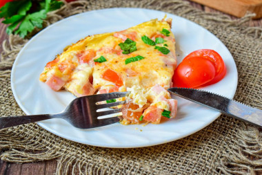 Omelet with ham and cheese in a frying pan