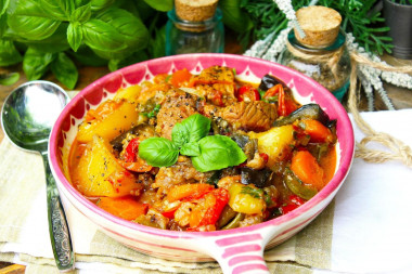 Vegetable stew in a cauldron with meat and potatoes on a campfire