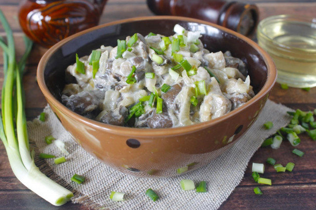 Oyster mushrooms in sour cream in a frying pan